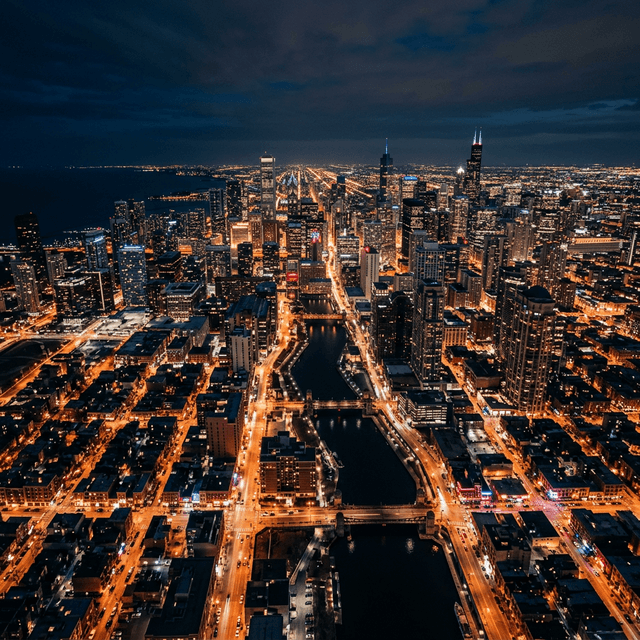 Aerial view of Chicago neighborhoods at night with glowing streets